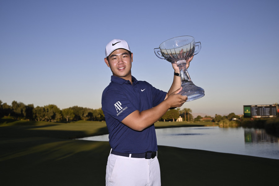 Tom Kim hält eine Trophäe hoch