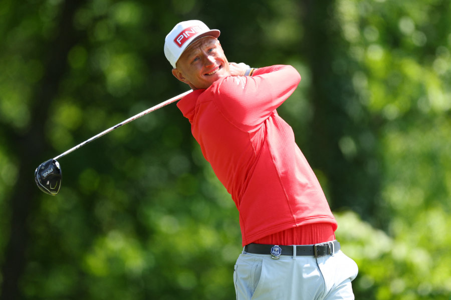 Golfer Adrian Meronk in roter Jacke beim Abschlag