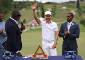 Golfer Camilo Villegas winkt vor einer Trophäe
