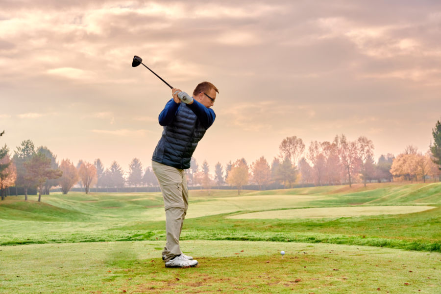 Ein Golfer schlägt auf einem winterlichen Platz ab