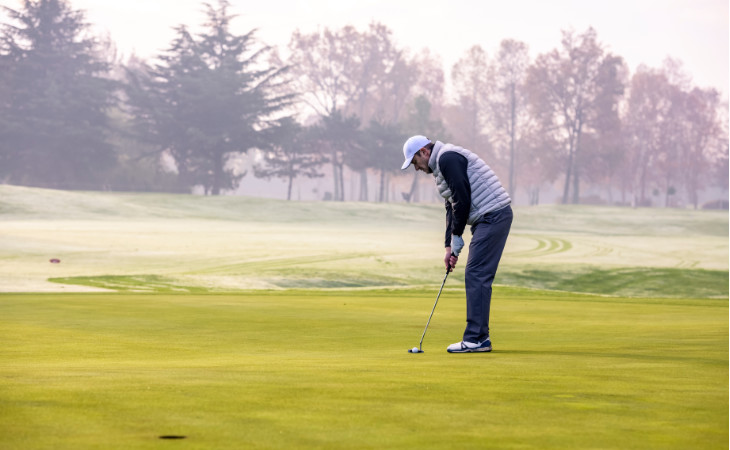 Ein Golfer puttet auf einem winterlichen Platz