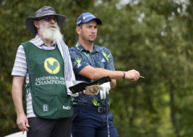 Golfer Lucas Herbert neben einem Caddie mit weißem Rauschebart