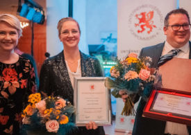 Ministerpräsidentin Manuela Schwesig sowie ein Mann und eine Frau mit Urkunden und Blumensträußen