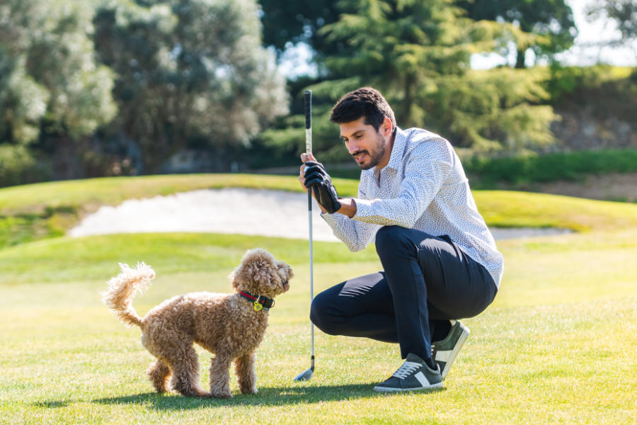 Ein Golfer mit einem kleinen Hund