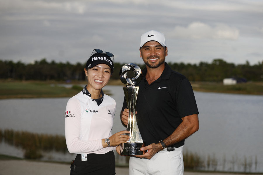 Ein Golfer und eine Golferin präsentieren gemeinsam eine Trophäe