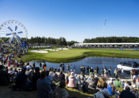 Ein Riesenrad und ein Wasserhindernis auf einem gut besuchten Golfplatz