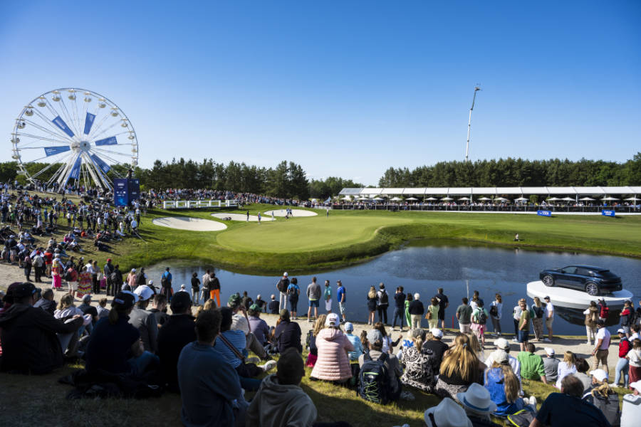 Ein Riesenrad und ein Wasserhindernis auf einem gut besuchten Golfplatz