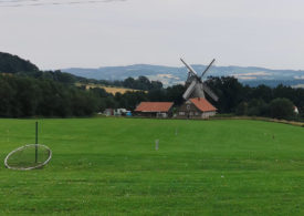 Eine Windmühle hinter einem Golfplatz
