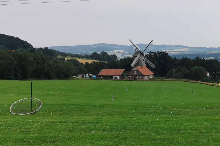 Eine Windmühle hinter einem Golfplatz