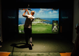 Ein Golfer schlägt auf einer Trackman Indoor Golfanlage ab