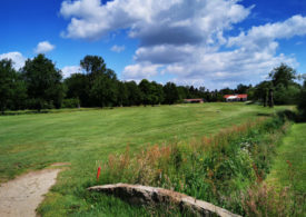 Eine Steinbrücke und ein Clubhaus auf einem Golfplatz