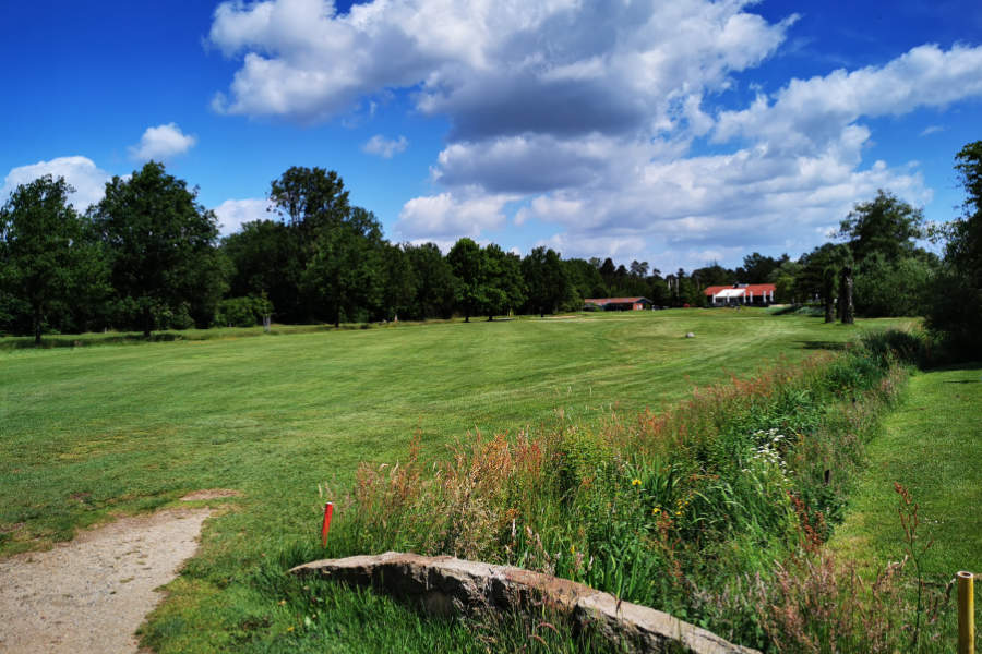 Eine Steinbrücke und ein Clubhaus auf einem Golfplatz