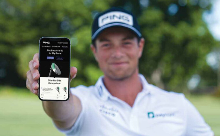 Viktor Hovland hält ein Handy mit der neuen App von Ping ins Bild