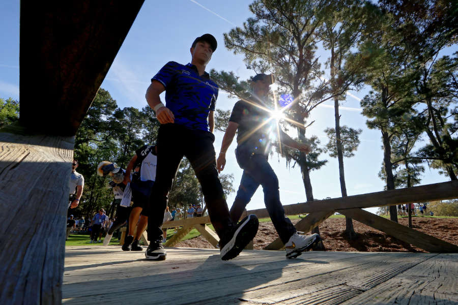 Viktor Hovland und Rory McIlroy laufen über eine Brücke im TPC Sawgrass