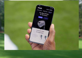 Eine Hand hält ein Handy, auf dem Screen sieht man eine Golf-App