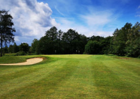 Ein Golfplatz mit Sandbunker unter blauem Himmel