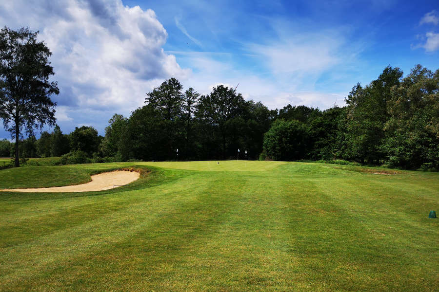 Ein Golfplatz mit Sandbunker unter blauem Himmel