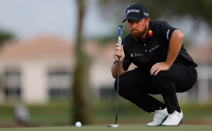 Shane Lowry hockt vor dem Ball auf dem Green