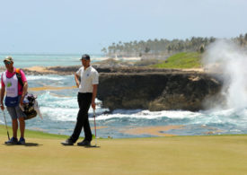 Ein Golfer lehnt auf seinem Putter auf einem Golfplatz in der Karibik