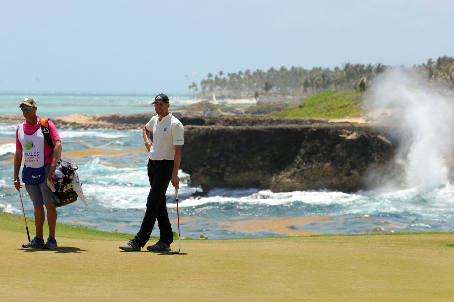 Ein Golfer lehnt auf seinem Putter auf einem Golfplatz in der Karibik
