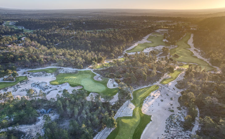 Ein Golfplatz mit vielen Sandbunkern und viel Wald ringsum