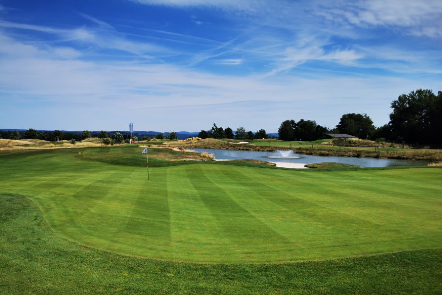 Ein Green und ein Teich auf einem Golfplatz