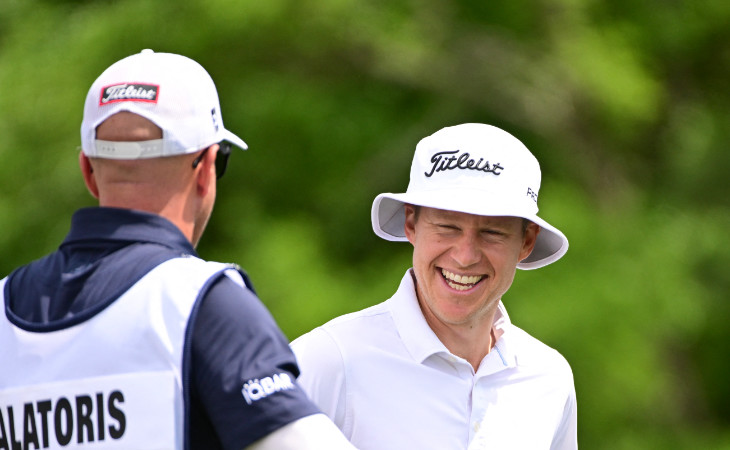 Peter Malnati grinst breit während er seinen weißen Fischerhut von Titleist trägt