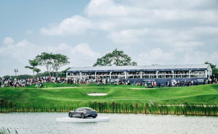Ein Auto von Porsche in der Mitte eines Teiches auf einem Golfplatz