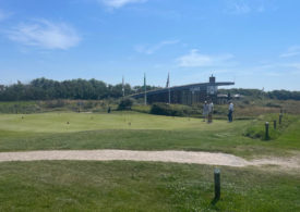 Drei Männer vor dem Clubhaus eines Golfclubs