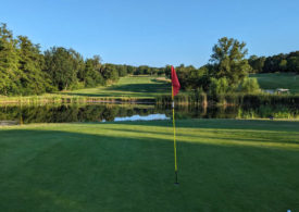 Eine Fahne vor einem Teich auf einem Golfplatz