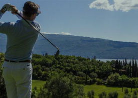 Ein Golfer schlägt vor dem Gardasee ab