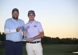 J.T. Poston und sein Caddie präsentieren die Trophäe der Shriners Children's Open.