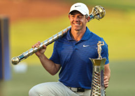 Rory McIlroy mit den Trophäen für den Gewinn der DP World Tour Championship