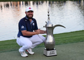Tyrrell Hatton posiert mit der Trophäe des Dubai Desert Classic